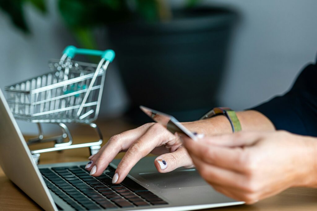 close-up of a woman hands buying online with a credit card and a laptop, e-commerce concept